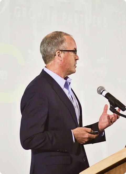 Jude Rake delivering a keynote behind a podium